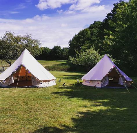 Two bell tents in a field
